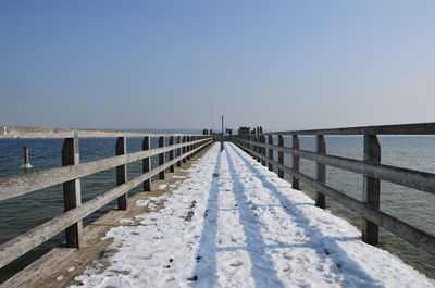 Pier over sea against clear sky