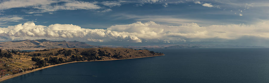 Scenic view of sea and mountains against sky