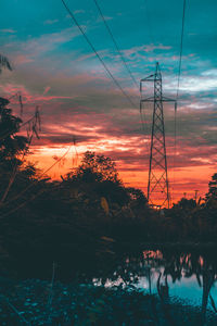 Silhouette electricity pylon against sky during sunset