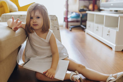 Portrait of young woman sitting at home