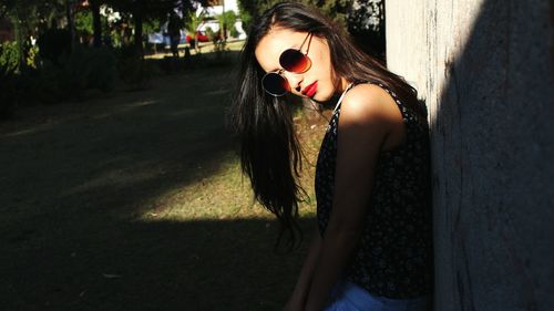 Portrait of young woman with shadow on tree