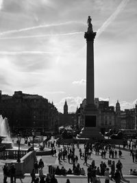 People at town square against sky in city