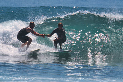 Men surfing in sea