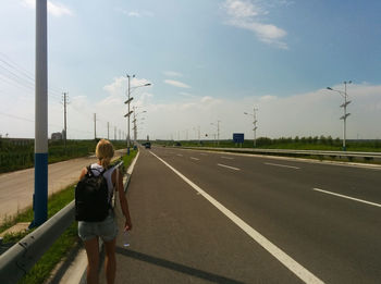 Rear view of man walking on road