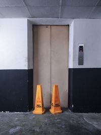 Fire hydrant against orange wall in city