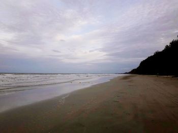 View of beach against cloudy sky