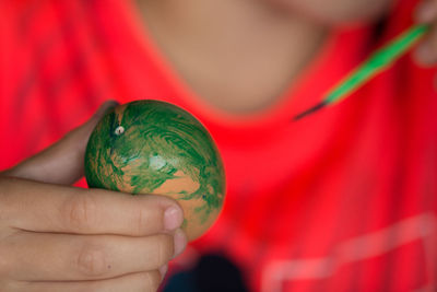 Midsection of woman painting easter egg