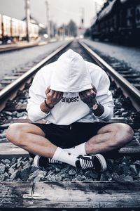 Man sitting on railroad track