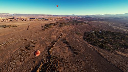 Hot air balloon flying over landscape against sky