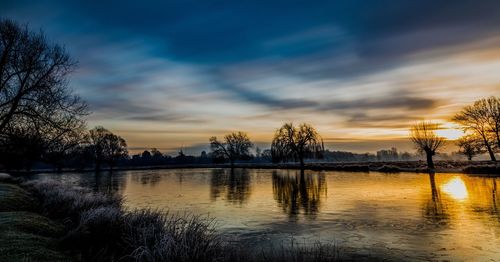 Scenic view of silhouette trees against sky at sunset