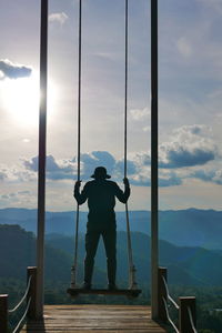 Low angle view of man standing on railing