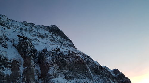 Low angle view of snowcapped mountain against sky