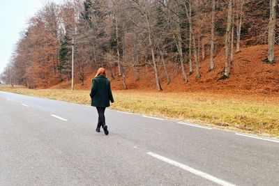 Rear view of man walking on road