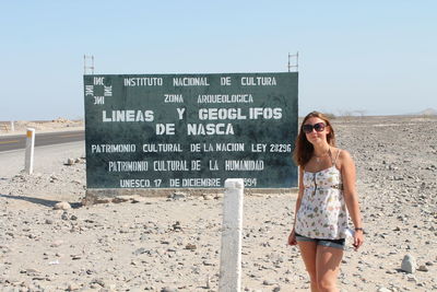 Full length of young woman standing on beach