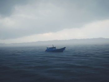 Boat sailing in sea against sky