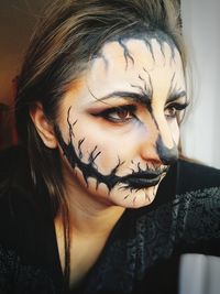 Close-up of thoughtful young woman with spooky halloween make-up