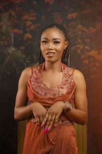 Portrait of an elegant young woman standing before a flowery tree