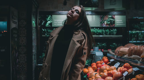 Woman standing by vegetables for sale in market