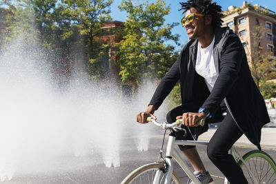 Man riding bicycle by fountain