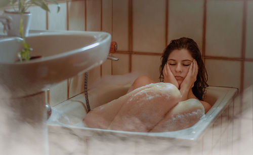 Woman looking away in bathroom at home