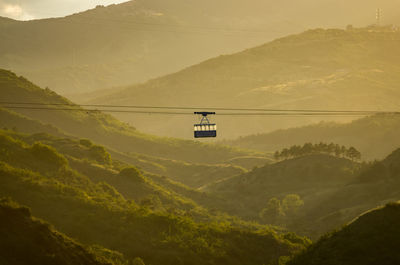 Overhead cable car on mountains against sky