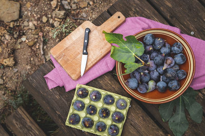 Purple black figs on a rustic wooden picnic table