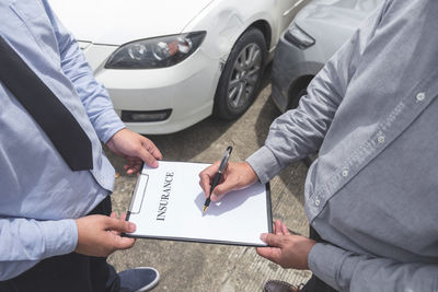 Low section of customer signing application form held by agent