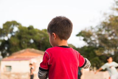 Rear view of boy against trees