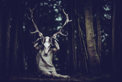 Woman holding antler in forest