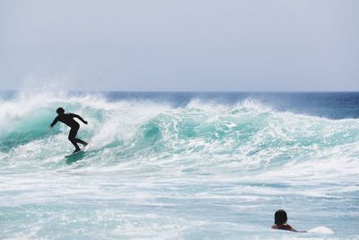 Man surfing in sea against clear sky