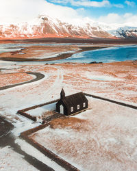 High angle view of house on field against mountains during winter