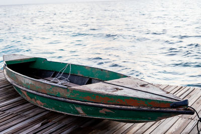 Old wooden boat sitting on the pier overlooking the beautiful turquoise sea.