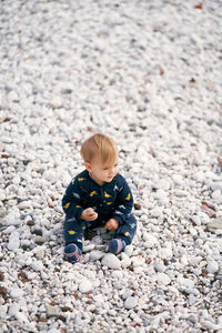 High angle view of boy on pebbles