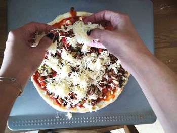 Close-up of hand holding pizza