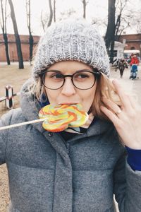 Woman looking away while eating lollipop