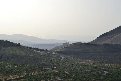Scenic view of field and mountains against clear sky