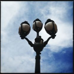 Low angle view of street light against cloudy sky