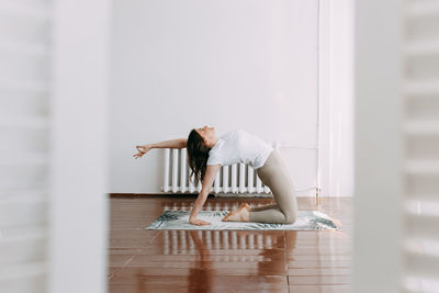 A girl in sportswear goes in for sports with yoga, exercises and fitness in the studio