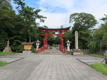 Footpath leading towards temple against sky