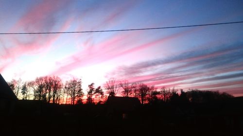 Low angle view of silhouette trees against sky at sunset