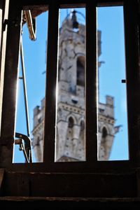 Close-up of cross against sky seen through window