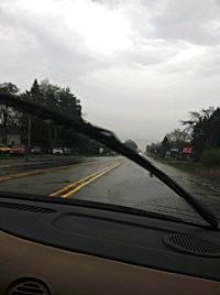 Cars on road against cloudy sky