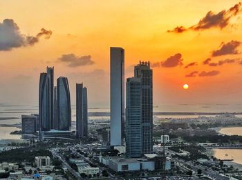 Modern buildings against sky during sunset