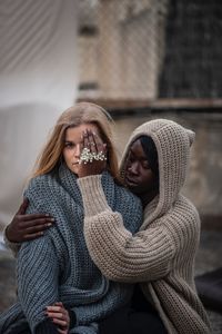 Woman covering friend eye in city