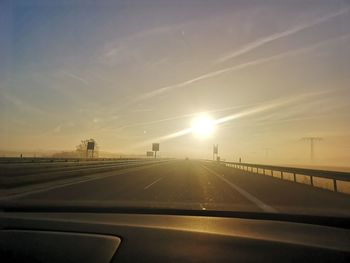 Highway seen through car windshield during sunset