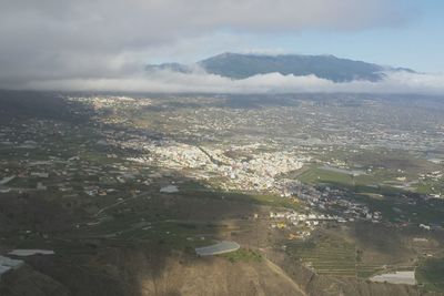 Aerial view of city by sea against sky