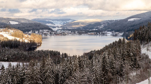 Scenic view of lake by snowcapped mountains against sky