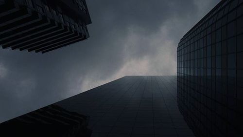 Low angle view of modern building against cloudy sky