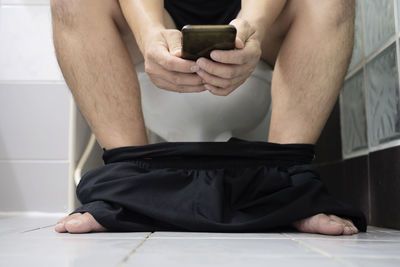 Man spends time in the bathroom, on the toilet. guy play phone in the toilet. selective focus.