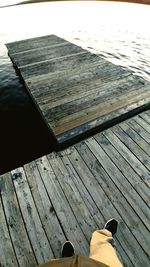 Low section of person standing on hardwood floor